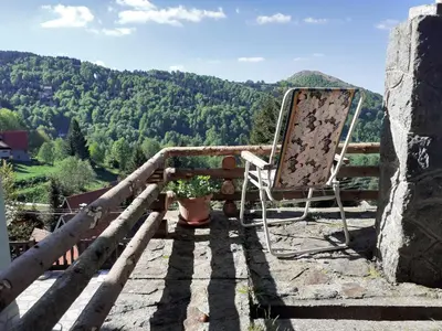 a chair sitting on a balcony with a view at Studio za dvoje u Planinskoj kući Savić in Kopaonik