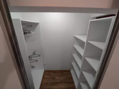 a walk in closet with white shelves at Malevilla Apartment in Vrnjačka Banja