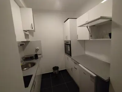 a small kitchen with white cabinets and a sink at Malevilla Apartment in Vrnjačka Banja