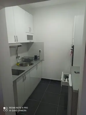 a small kitchen with white cabinets and a sink at Malevilla Apartment in Vrnjačka Banja