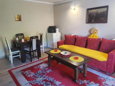 a living room with a red couch and a table at Guest House Jasmin in Niška Banja