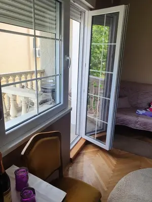 a room with a door to a balcony with a table at Guest House Jasmin in Niška Banja