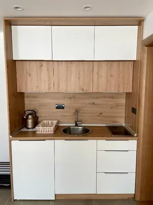 a kitchen with white cabinets and a sink at Zlatna Kruna - Lux Apartments Kopaonik in Kopaonik