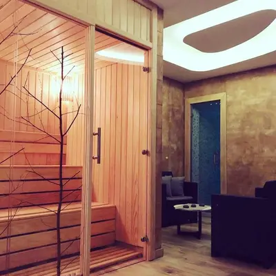 a living room with a glass door and a chair at Zlatna Kruna - Lux Apartments Kopaonik in Kopaonik