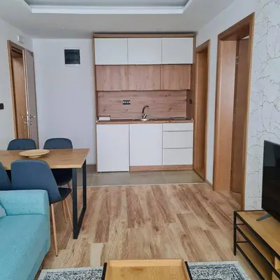 a living room with a table and a kitchen at Zlatna Kruna - Lux Apartments Kopaonik in Kopaonik