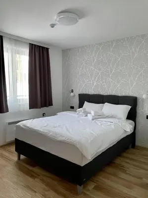 a bedroom with a large bed with white sheets at Zlatna Kruna - Lux Apartments Kopaonik in Kopaonik