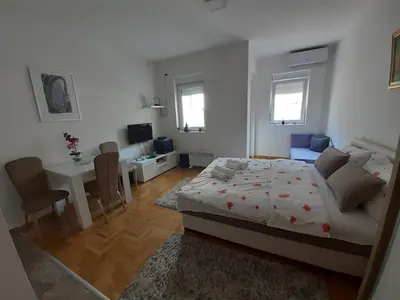 a bedroom with a bed and a dining room at Lena7 in Vrnjačka Banja
