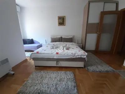 a bedroom with a bed in the corner of a room at Lena7 in Vrnjačka Banja