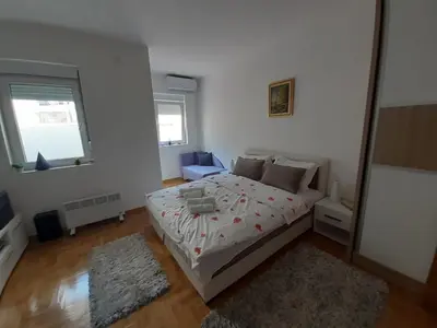a white bedroom with a bed and a mirror at Lena7 in Vrnjačka Banja