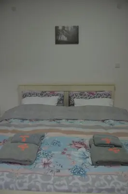 a bed with three pillows on top of it at Apartman Rajak in Vrnjačka Banja