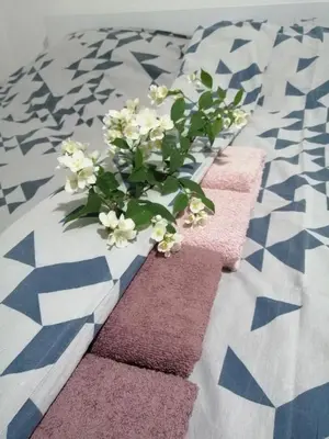 a bouquet of white flowers on a bed at Apartman Nana Jagodina in Jagodina