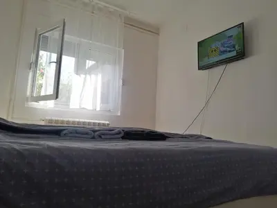 a bed in a white room with a window at Apartman Nana Jagodina in Jagodina