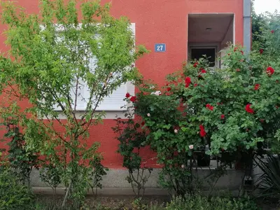 a red building with flowers in front of a window at Apartman Nana Jagodina in Jagodina
