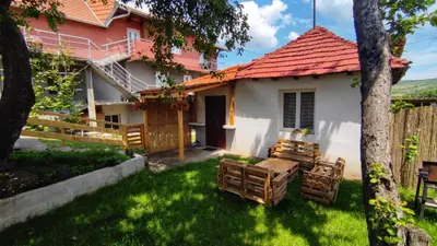 a house with a red roof and chairs in the yard at Kuća za odmor Apartman Solo in Soko Banja