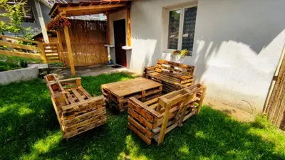 a group of wooden chairs and a table in the grass at Kuća za odmor Apartman Solo in Soko Banja