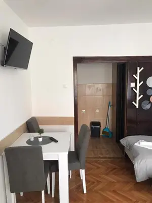 a room with a dining table and a bed at Smeštaj Filipović in Soko Banja