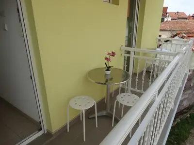 a small table on a balcony with two stools at Vila Jenic in Soko Banja