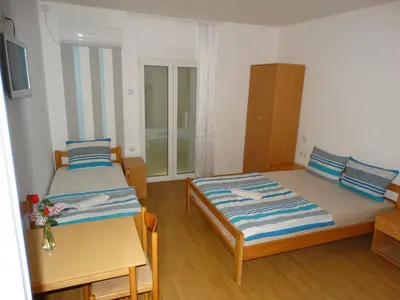 a small room with two beds and a table at Vila Jenic in Soko Banja