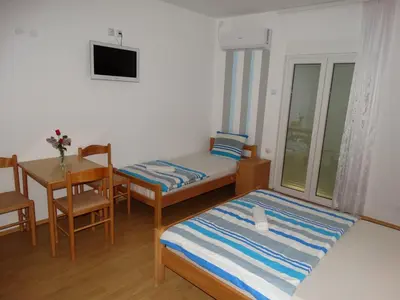 a small room with a bed and a table and a desk at Vila Jenic in Soko Banja