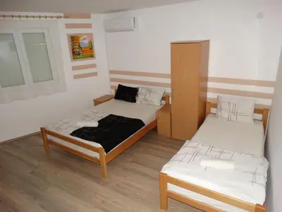 a small room with two beds and a window at Vila Jenic in Soko Banja