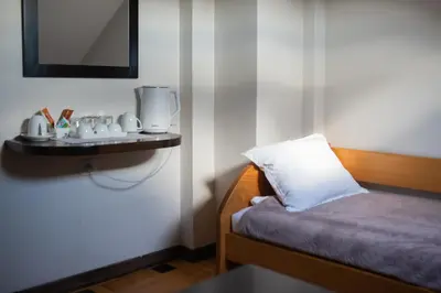 a room with a bed with a pillow and a mirror at Pleasure Čair apartments in Niš