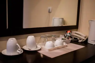 a bathroom counter with cups and plates and a mirror at Pleasure Čair apartments in Niš