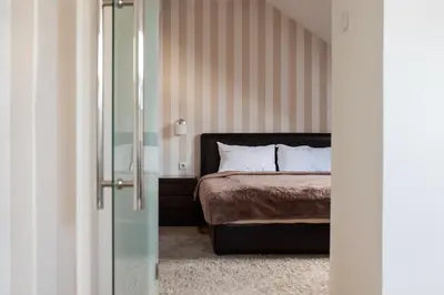 a bedroom with a bed and a glass door with a glass door at Pleasure Čair apartments in Niš