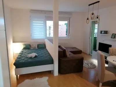 a small room with a bed and a chair in it at Emili Apartman in Jagodina