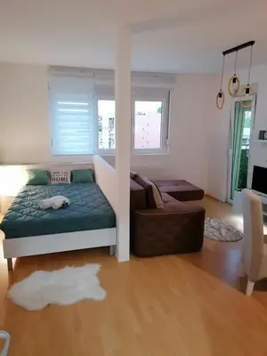 a bedroom with a bed and a couch and a chair at Emili Apartman in Jagodina