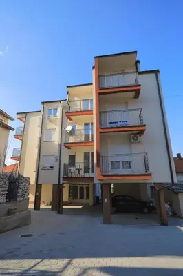 a large apartment building with its reflection in a mirror at Apartman Alegro in Soko Banja