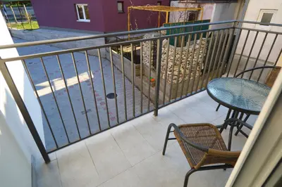 a balcony with a table and chairs and a fence at Apartman Alegro in Soko Banja