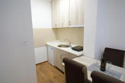 a small kitchen with a table and a sink at Apartman Alegro in Soko Banja