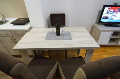 a table with a bottle of wine and two glasses at Apartman Alegro in Soko Banja