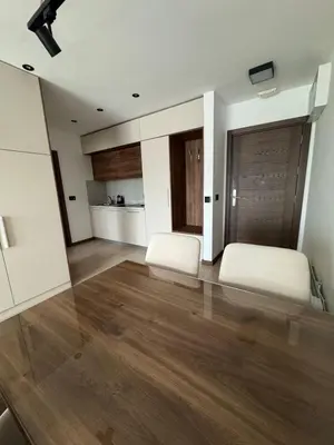 a living room with two white beds and wooden floors at Harry apartments - Apart & spa Zoned Kopaonik, Special offer for Genius status, in addition, we offer special benefits for children up to 17 years old!!! in Kopaonik