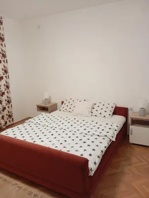 a bedroom with a large bed with white and black sheets at Apartman Bozic in Vrnjačka Banja