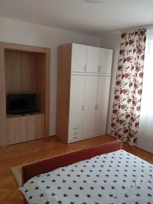 a bedroom with a bed and a cabinet and a television at Apartman Bozic in Vrnjačka Banja
