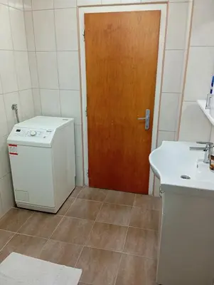a kitchen with a stove and a sink and a door at Apartman Bozic in Vrnjačka Banja