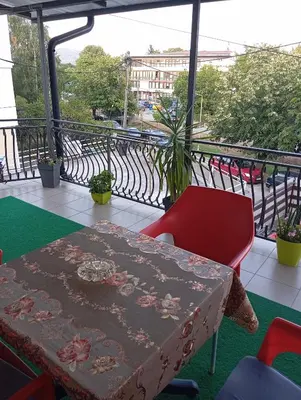 a table and a red chair on a balcony at Apartman Bozic in Vrnjačka Banja