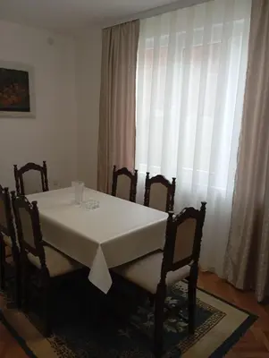 a table and chairs with a white table and a window at Apartman Bozic in Vrnjačka Banja