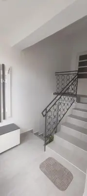a staircase in a white room with a rug at Apartman Bozic in Vrnjačka Banja