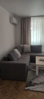 a living room with a couch in front of a window at Apartman Bozic in Vrnjačka Banja