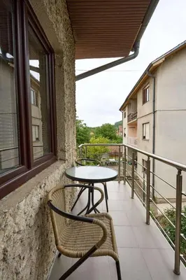 a patio with a table and chairs on a balcony at Apartmani Dr. Gaša in Soko Banja