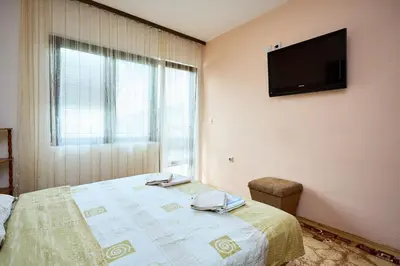 a bedroom with a bed with a television on the wall at Apartmani Dr. Gaša in Soko Banja
