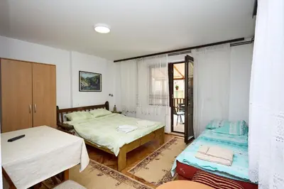 a bedroom with two beds and a window at Apartmani Dr. Gaša in Soko Banja