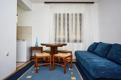 a living room with a table and a blue couch at Apartmani Dr. Gaša in Soko Banja
