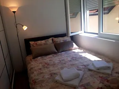 a bedroom with a bed with two pillows and a window at Apartman RADOVIĆ in Vrnjačka Banja