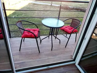 a patio with two chairs and a table on a porch at Apartman RADOVIĆ in Vrnjačka Banja