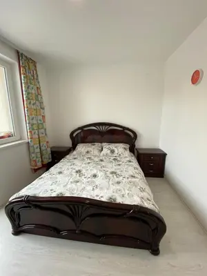 a bed in a room with a bed in the corner at Apartmani JOVANOVIC Sokobanja in Soko Banja