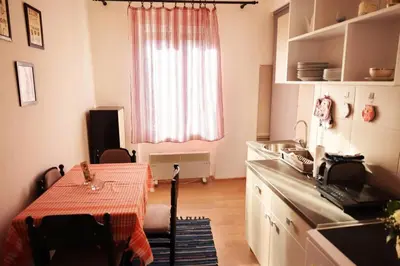 a kitchen with a table and a sink and a window at Viki Apartment CENTAR in Niš