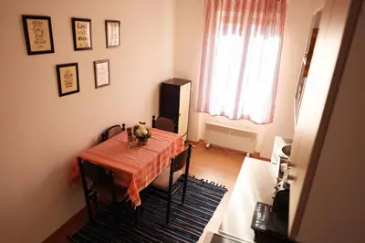 a dining room with a table and chairs and a window at Viki Apartment CENTAR in Niš